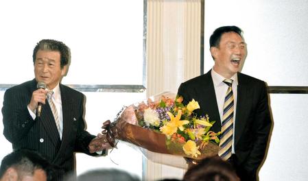　東北福祉大学硬式野球部ＯＢ会で大竹野球部長（左）から花束を手渡される金本監督