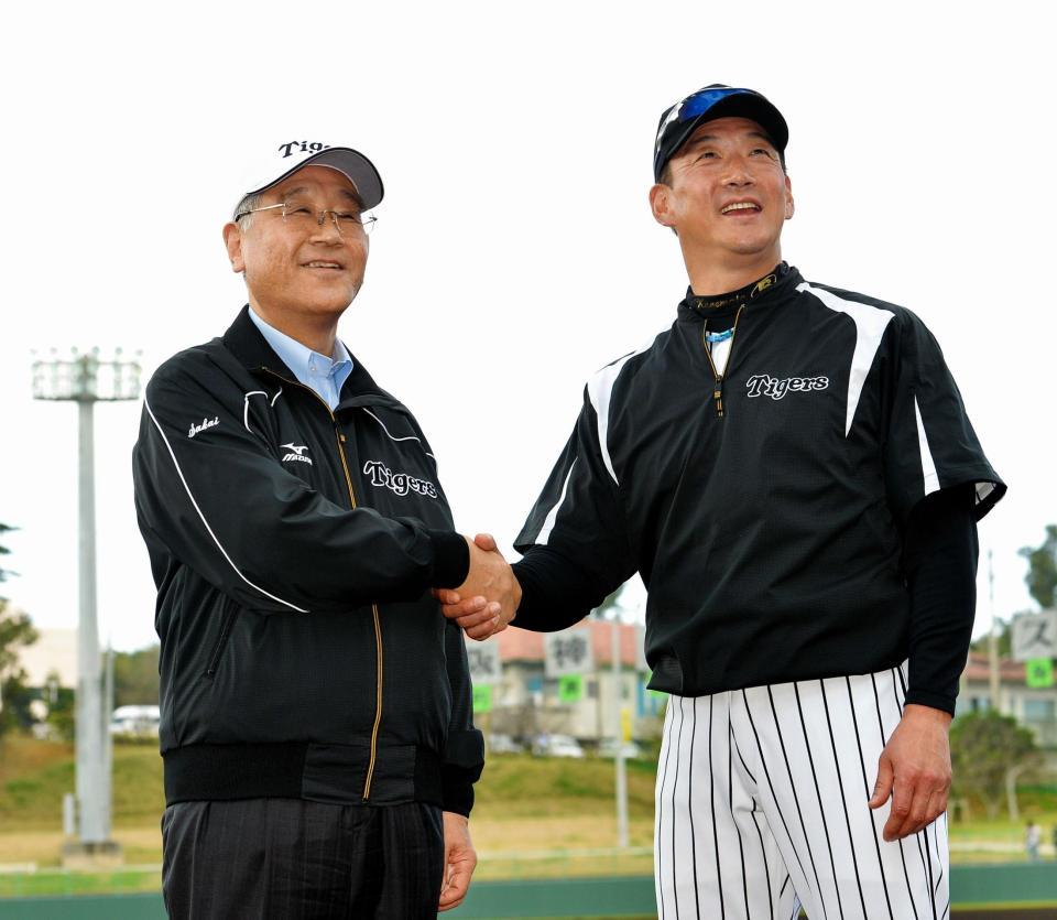 坂井信也オーナーと笑顔で握手する金本知憲監督（右）＝沖縄・宜野座村野球場