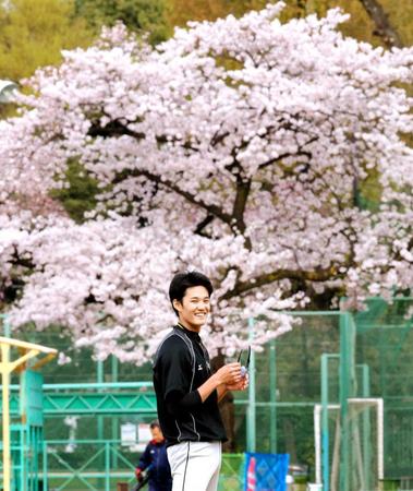 　満開の桜を背に笑顔を見せる藤浪（撮影・飯室逸平）