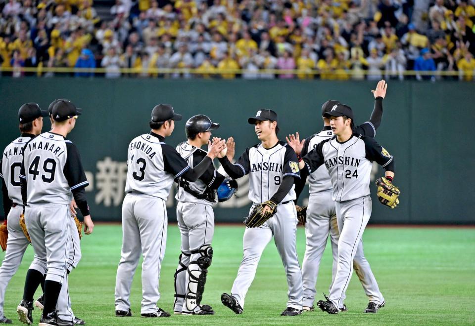 　初戦を快勝し、タッチを交わす高山（中央右）ら阪神ナイン（撮影・出月俊成）