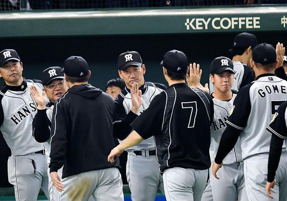 巨人に大勝しナインをタッチで迎える阪神・金本監督（中央）＝東京ドーム（撮影・園田高夫）