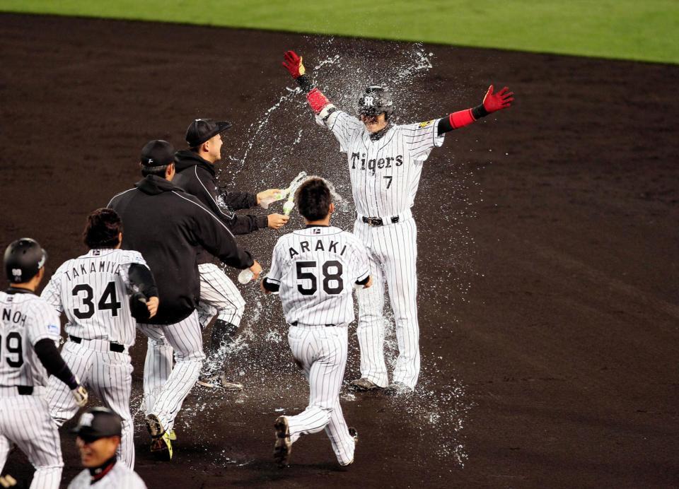 殊勲打を放った阪神・西岡剛は最初の祝福を受ける＝甲子園