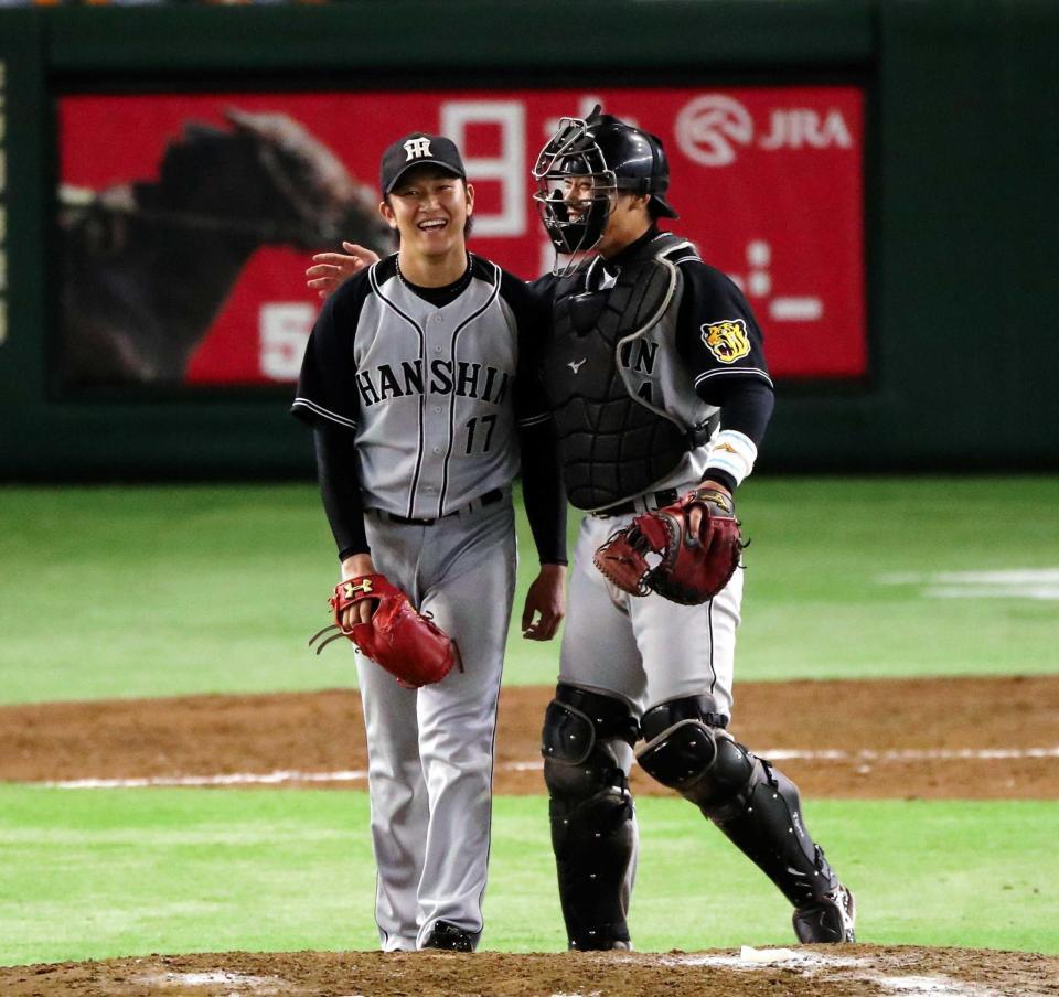 　完封勝利の岩貞（左）を祝福する原口（撮影・飯室逸平）