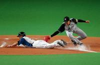 ６回、日本ハム・杉谷拳士のスクイズで本塁をつく日本ハム・西川遥輝（左）にタッチする阪神・岩貞祐太。一旦はセーフとなるが、ビデオ判定によりアウト＝札幌ドーム（撮影・高部洋祐）