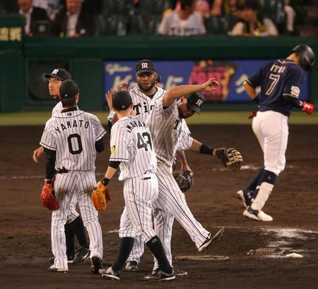 最後を締め、勝利のハイタッチをかわす阪神　ラファエル・ドリス（中央）ら阪神ナイン＝甲子園（撮影・飯室逸平）