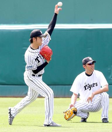 　金村コーチ（右）と話しながらキャッチボールする岩貞