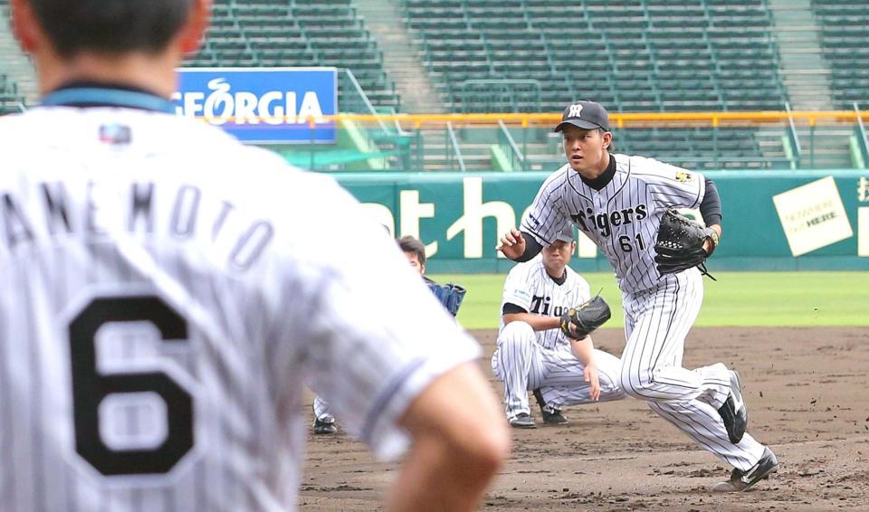 　金本監督（手前）が見守る中、ノックを受ける望月（撮影・飯室逸平）