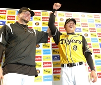 阪神・メッセンジャー（左）に右手を挙げられ、笑顔をみせる福留孝介＝甲子園（撮影・田中太一）