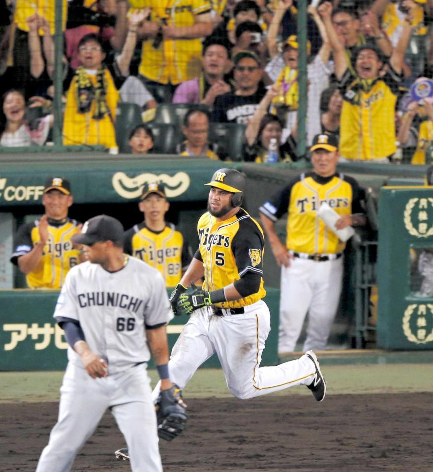 ８回、２点タイムリーを放ち、一塁へ駆けるゴメス。左端はベンチで手をたたいて喜ぶ金本監督　