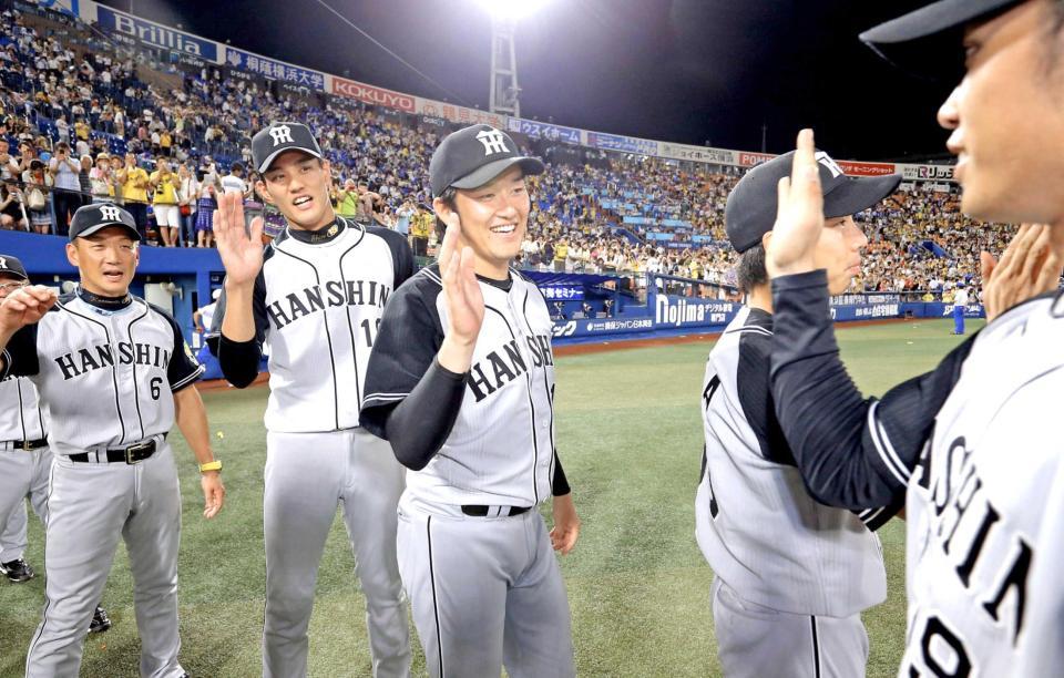 　ハイタッチでナインを迎える岩貞（中央）＝撮影・飯室逸平