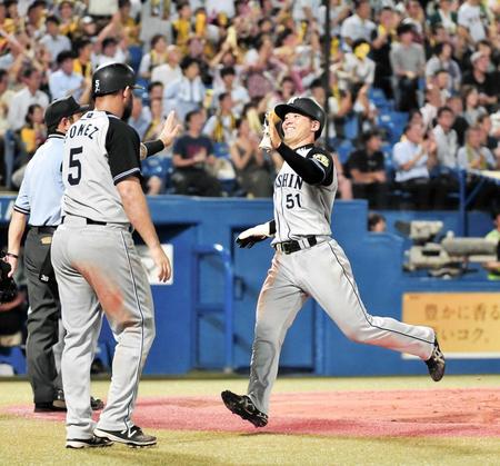　８回、高山の２点適時打で生還した伊藤隼はゴメス（左）と笑顔でタッチ