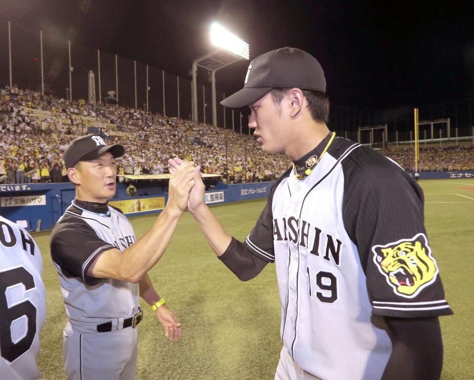 　金本監督と勝利のハイタッチをかわす藤浪（右）