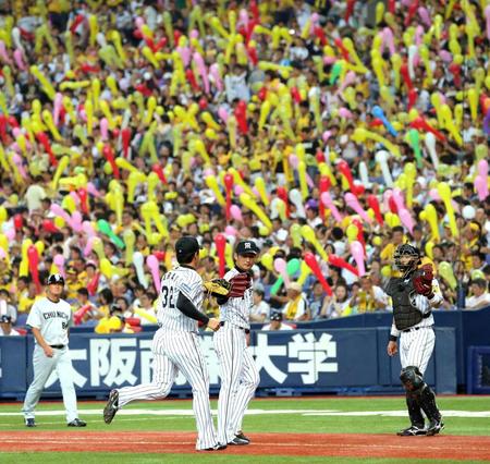 ７回、好守で盛り立てる阪神・新井良太とグラブタッチする阪神・岩崎優＝京セラドーム（撮影・飯室逸平）