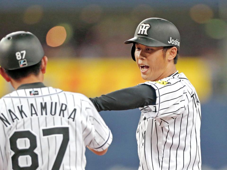 　８回、適時打を放ち、中村コーチ（左）とタッチを交わす高山＝撮影・高部洋祐