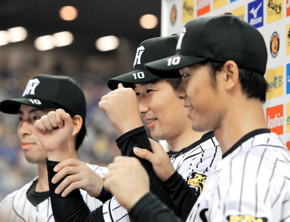 　藤村富美男氏の「１０」番を帽子に刻み、お立ち台で江越（左）、高山（右）とポーズを決める岩崎（撮影・高部洋祐）