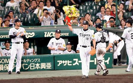 日本球界通算６００試合登板を達成し花束を掲げ声援に応える藤川