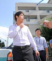 　移動前に記者の質問に答える高山