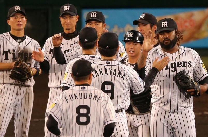 最後をしめ、ナインと勝利のハイタッチをかわす阪神　マルコス・マテオら阪神ナイン＝甲子園（撮影・飯室逸平）
