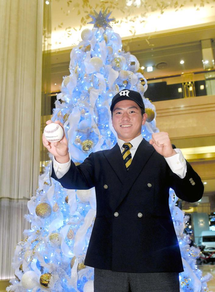 　仮契約を結びクリスマスツリーの前でポーズをとるドラフト７位指名の東北福祉大・長坂