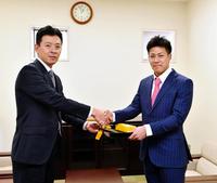 阪神・四藤慶一郎社長（左）から成人式の記念品を授与される阪神・植田海＝阪神球団事務所（撮影・高部洋祐）
