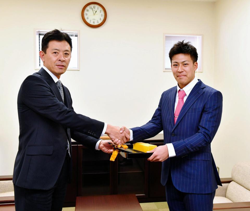 阪神・四藤慶一郎社長（左）から成人式の記念品を授与される阪神・植田海＝阪神球団事務所（撮影・高部洋祐）
