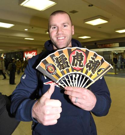 来日し、センスを手にサムアップする阪神　エリック・キャンベル＝大阪・伊丹空港（撮影・飯室逸平）