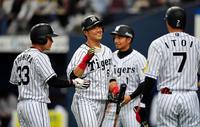 ９回、殊勲打を放った阪神・中谷（中央）は笑顔でナインとタッチを交わす＝京セラドーム大阪（撮影・北村雅宏）