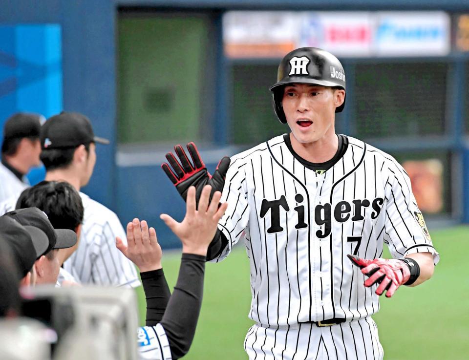 １回、鳥谷のタイムリーで生還し、ナインとタッチを交わす糸井　