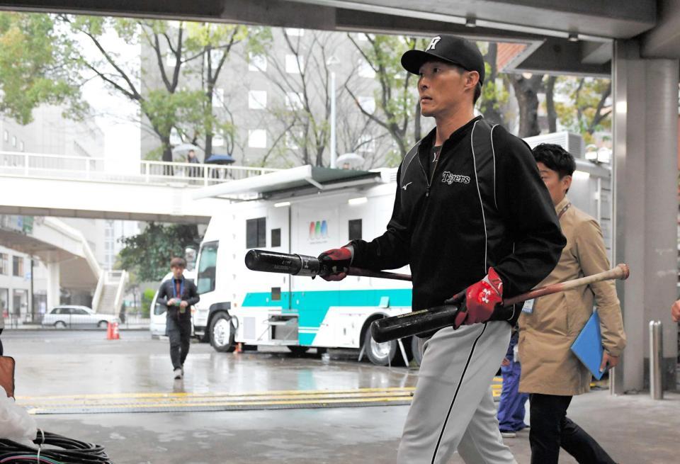 　両手にバットを持ち、室内練習場へ向かう糸井（撮影・出月俊成）