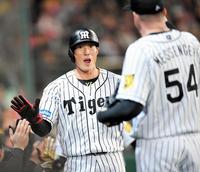 ３回、阪神・鳥谷の適時打で生還し、ナインとタッチを交わす糸井＝甲子園（撮影・北村雅宏）