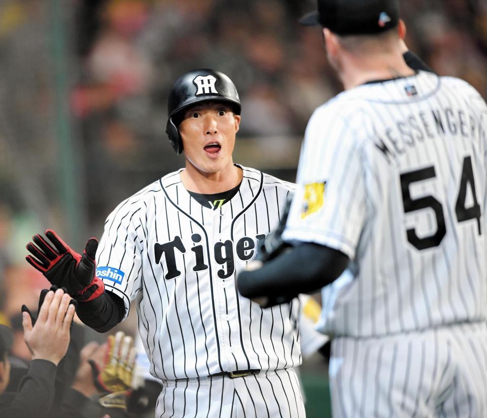 ３回、阪神・鳥谷の適時打で生還し、ナインとタッチを交わす糸井＝甲子園（撮影・北村雅宏）