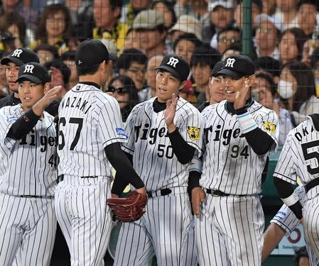 ６回、好リリーフを見せた阪神・岩崎優をハイタッチで迎える阪神・青柳晃洋ら＝甲子園（撮影・飯室逸平）