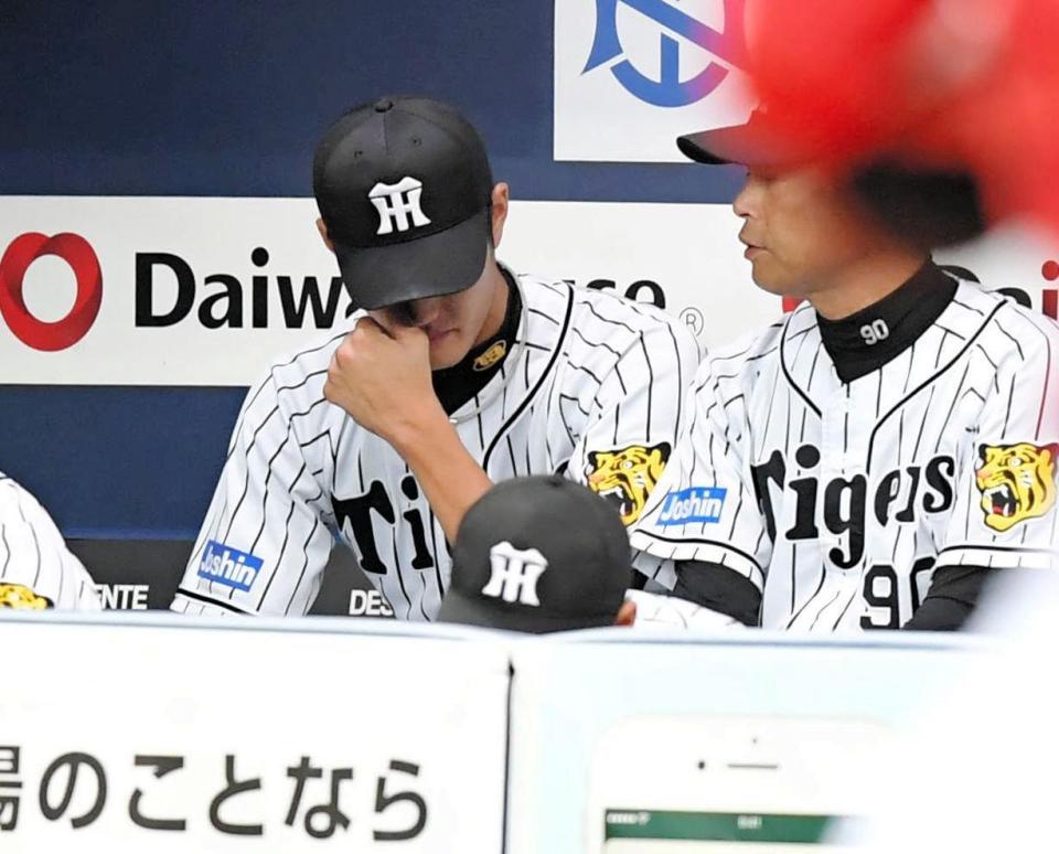 　５回途中に降板し、ベンチで涙を流す藤浪（左）