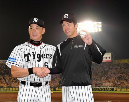 プロ初勝利を挙げ、ウイニングボールを手に金本監督（左）と握手を交わす小野