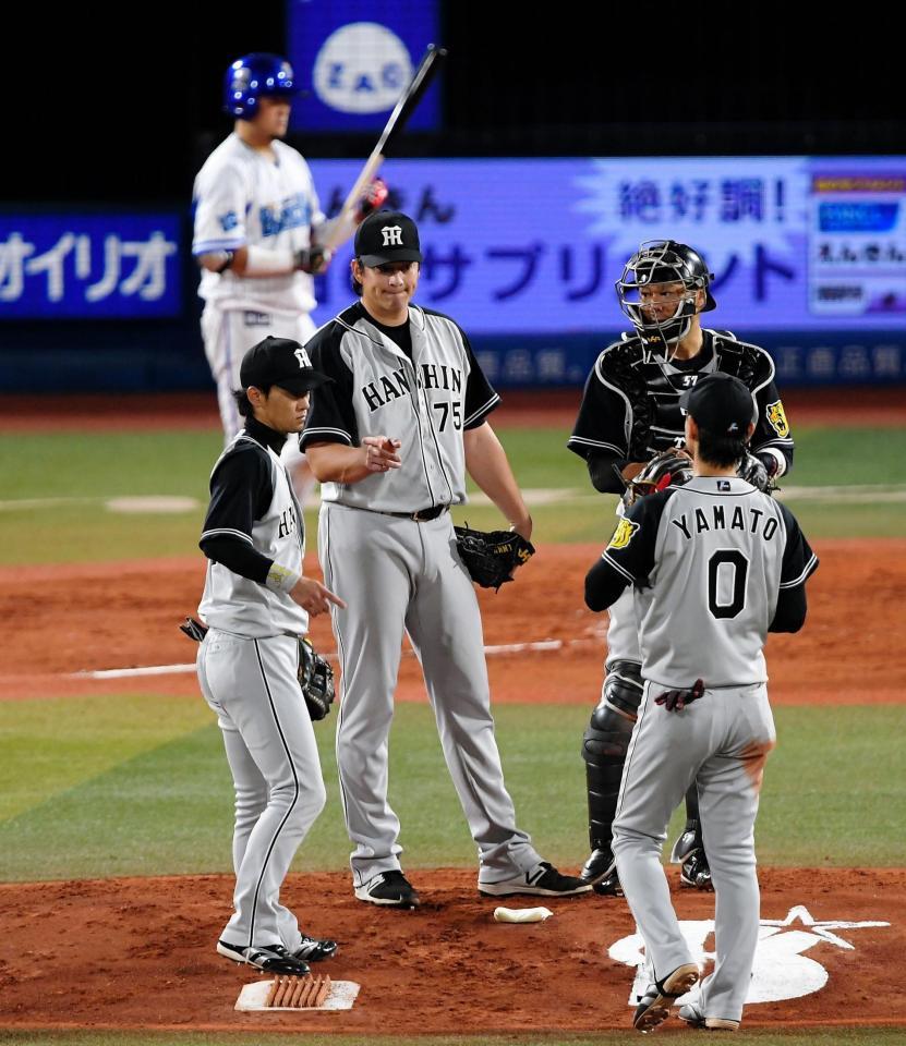 ４回、マウンドに集まる阪神のメンドーサ（左）と岡崎＝横浜スタジアム（撮影・堀内翔）