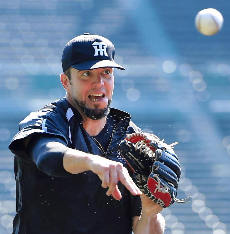 ノックを受けて汗を飛ばしながら返球するメッセンジャー＝甲子園