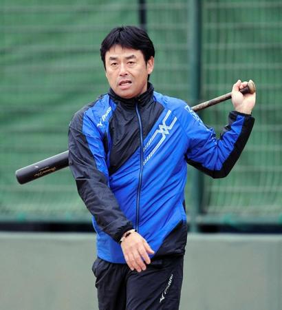 バットを振りながら練習を見る香田コーチ