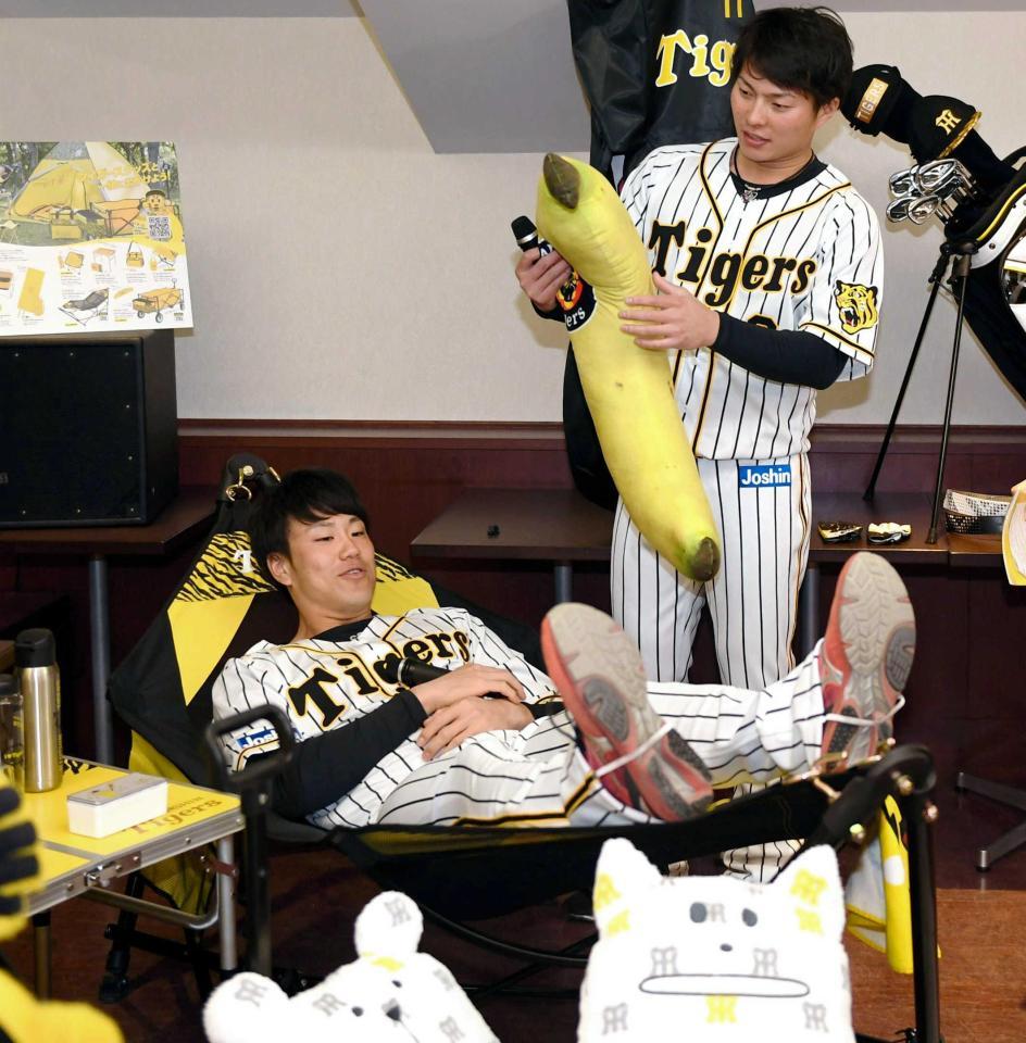 　阪神グッズのハンモックに寝そべる中谷（手前）とバナナクッションを持つ北條