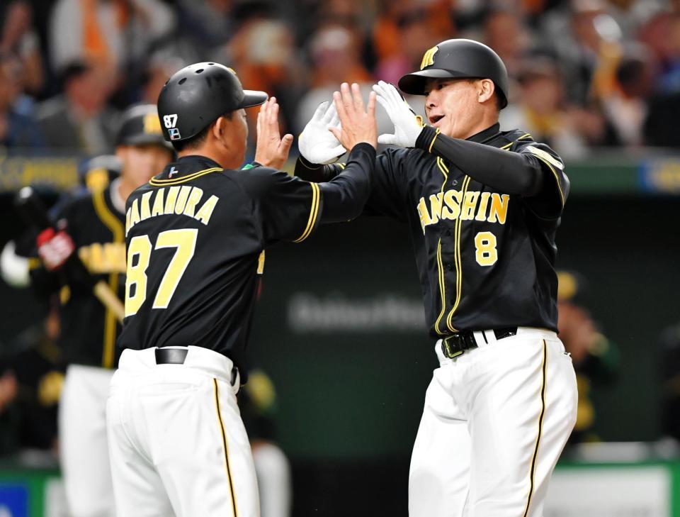 ２回阪神１死、先制ソロを放ち、中村豊コーチ（左）に迎えられる阪神・福留孝介＝東京ドーム（撮影・西岡正）