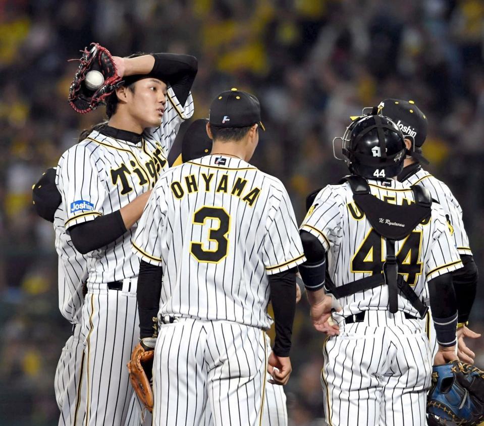 　２０日の巨人戦、ピンチを迎え帽子をとって、ひと息入れる藤浪（左）＝甲子園