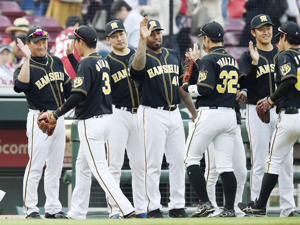 　広島に勝利し、笑顔でナインを迎える阪神・金本監督（左端）＝マツダ