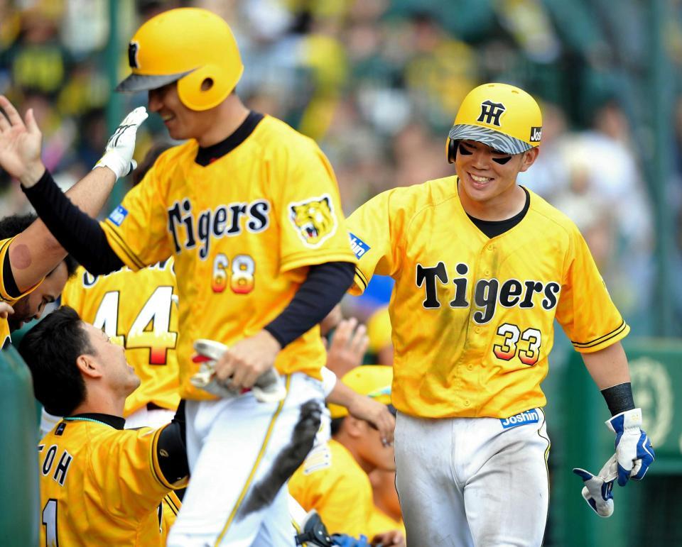 　７回、上本の適時打で生還し、ナインとタッチを交わす糸原（右）