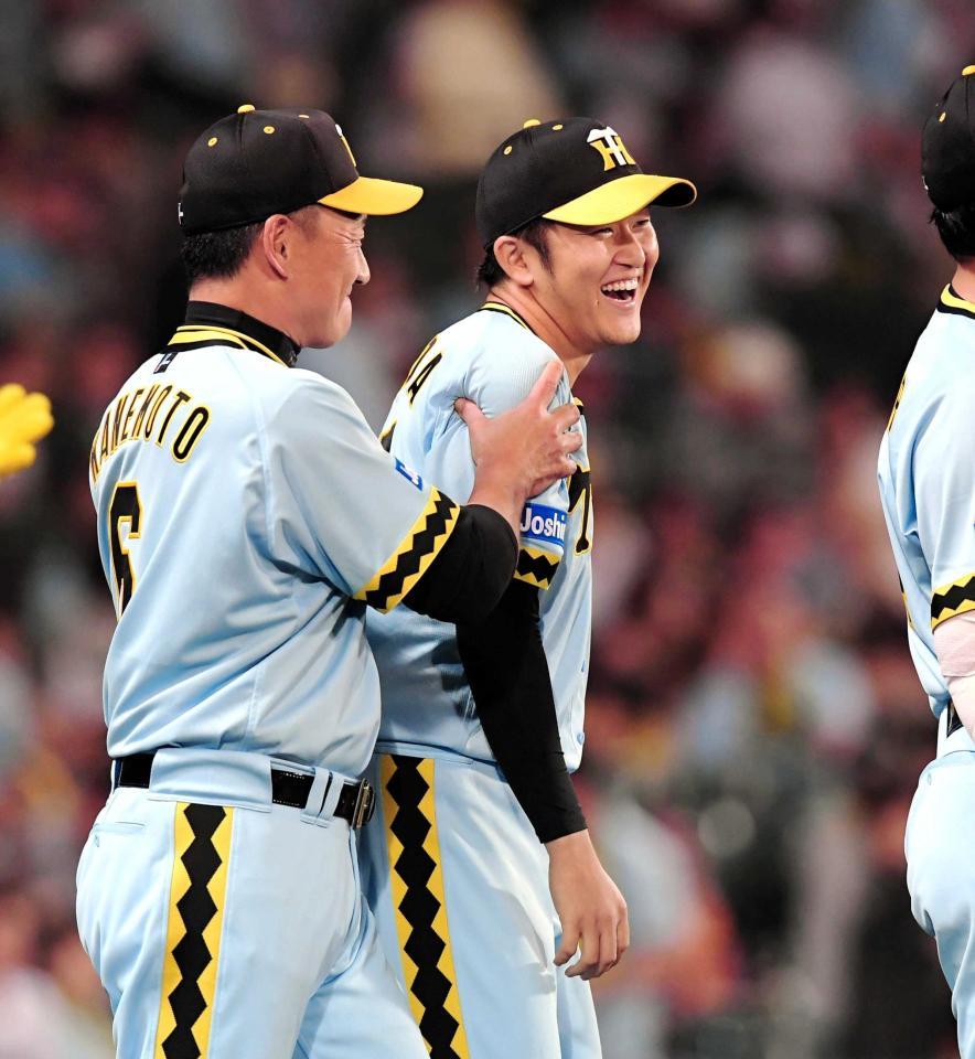 　巨人に勝利し、金本監督（左）に右腕をつかまれねぎらわれる岩貞