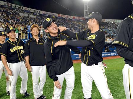 　通算１００勝目を挙げた能見（中央）は、鳥谷（右）から祝福され笑みを浮かべる。能見の左は藤川、同２人目は岩田（撮影・田中太一）