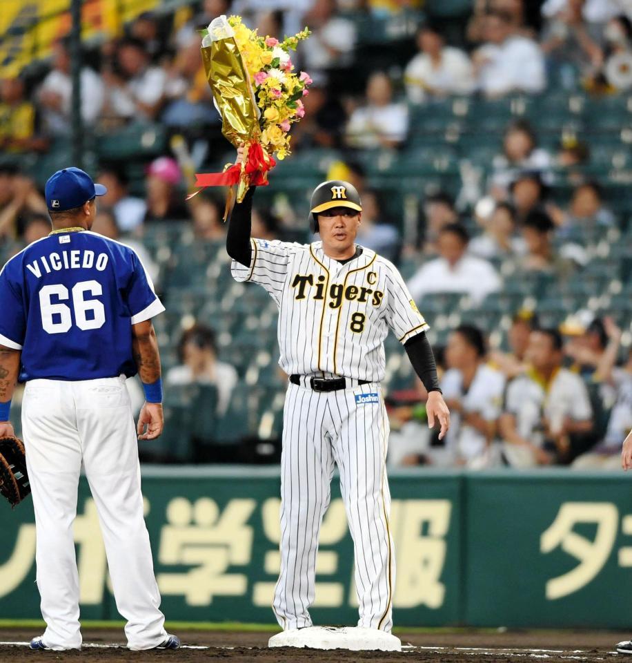 １回、プロ通算３０００塁打を達成した阪神・福留孝介は花束を掲げる＝甲子園（撮影・田中太一）