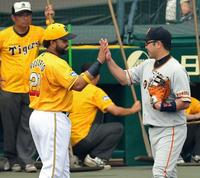 　試合前、巨人・阿部（右）とタッチを交わす阪神・ロサリオ