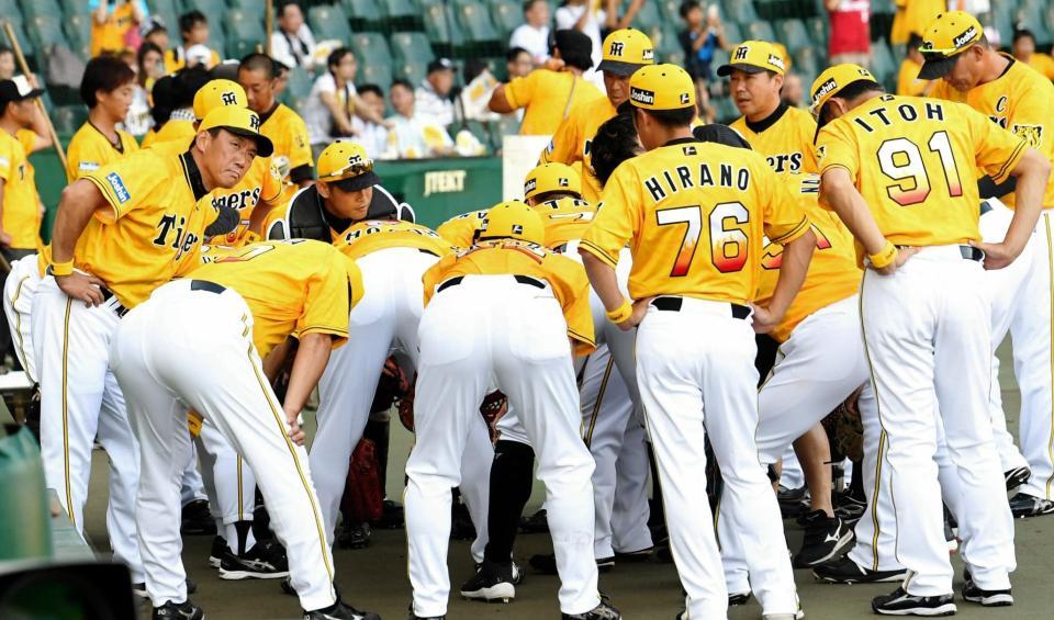 試合前、円陣を組むナイン。左は阪神・金本知憲監督＝甲子園
