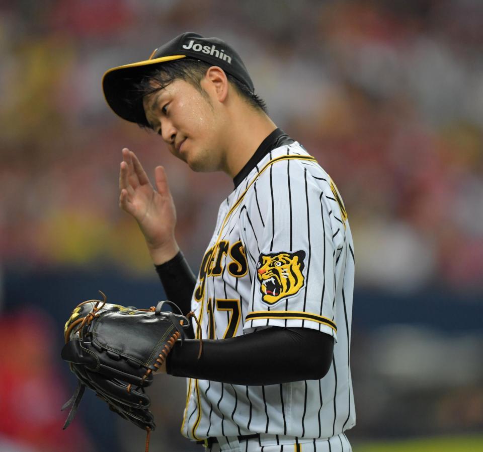 　４回、先制点を失い、汗を拭いながらベンチに戻る岩貞（撮影・北村雅宏）