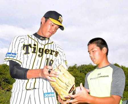 　サインを書き入れたグラブを手渡す藤浪（撮影・北村雅宏）