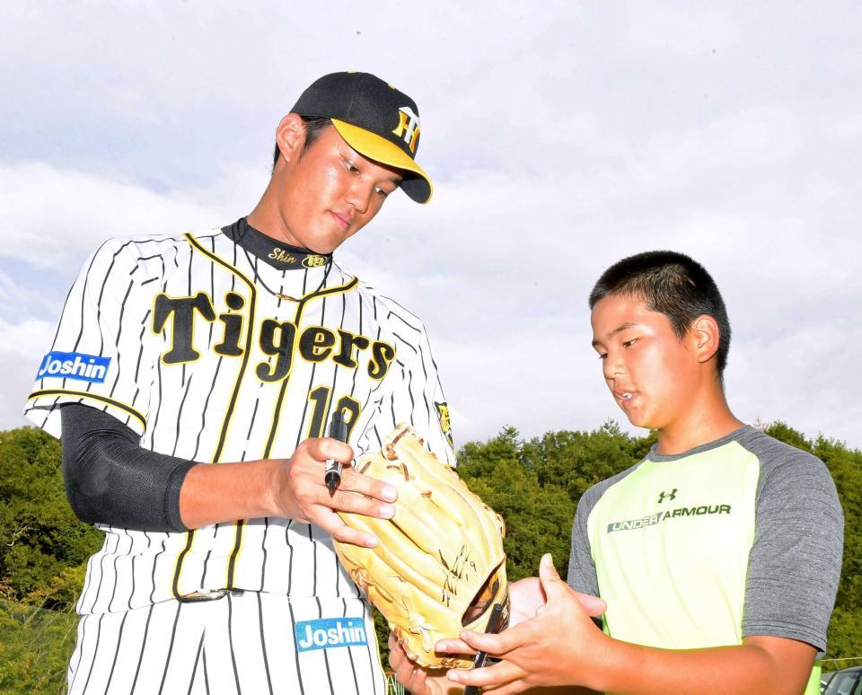 　サインを書き入れたグラブを手渡す藤浪（撮影・北村雅宏）